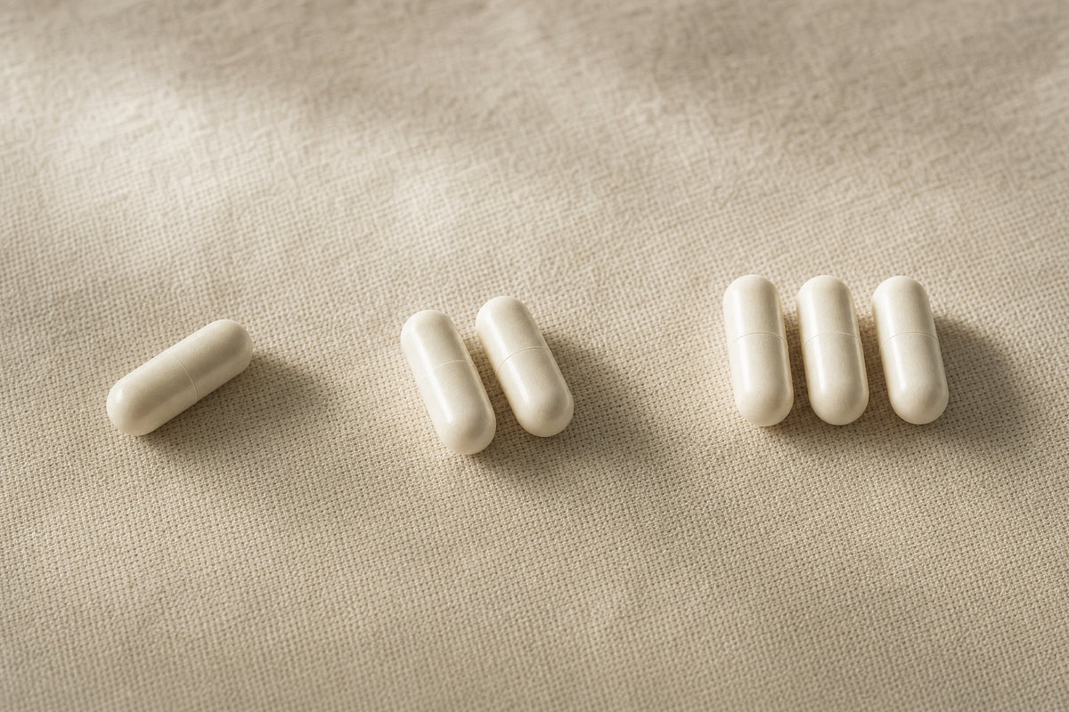 Plain ivory capsules on linen, set out as one, two and three