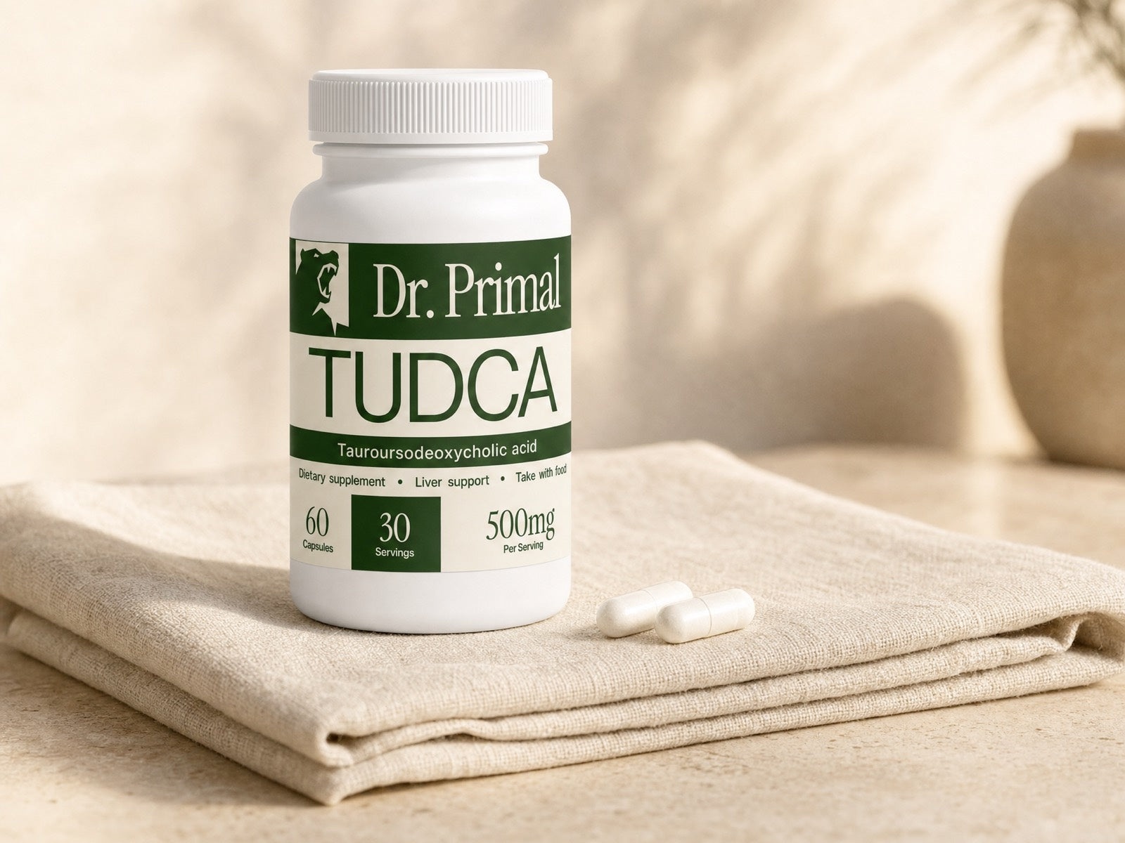 Dr.Primal TUDCA 500mg bottle on folded linen with two capsules beside it