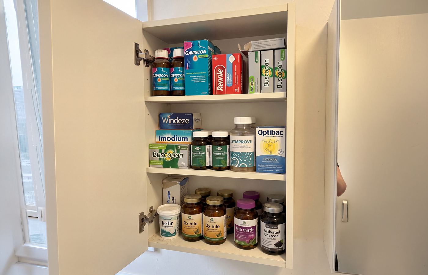 Bathroom cabinet full of half-used gut remedies and supplements